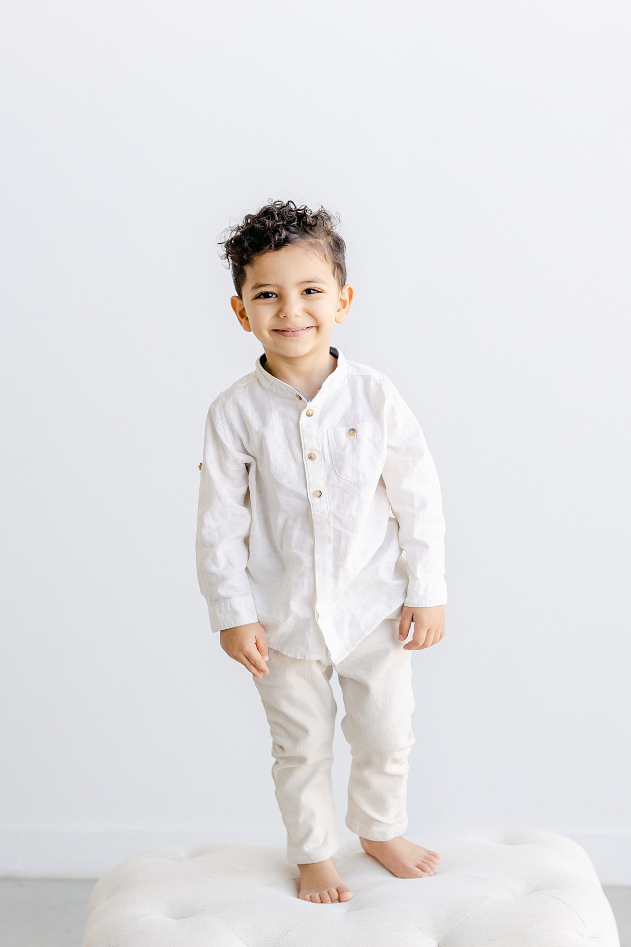 Adorable smiling boy in studio portrait by Sana Ahmed Photography.