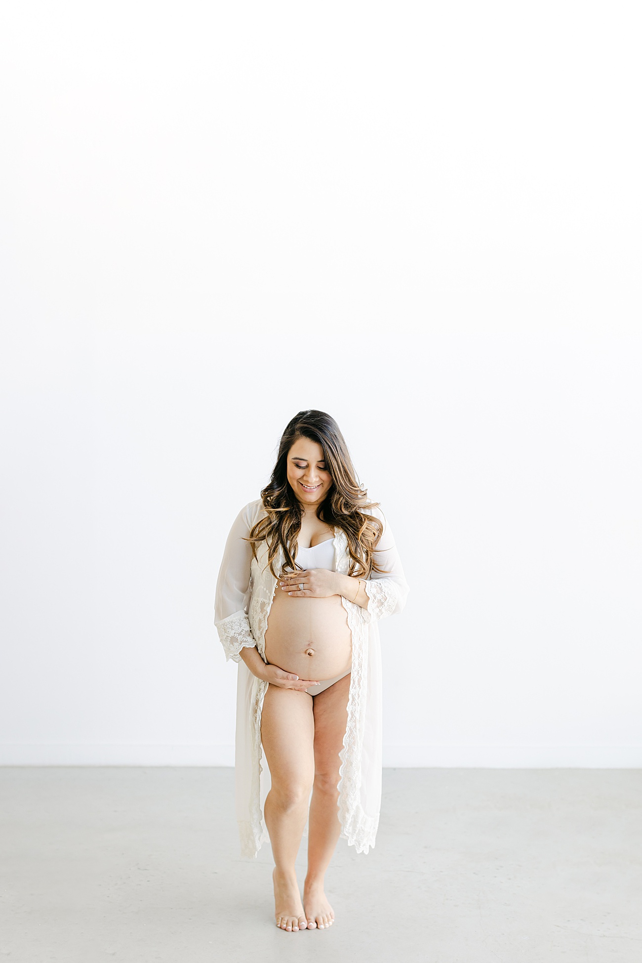 Intimate maternity portrait with Mom in white lace robe. Photo by Sana Ahmed Photography.