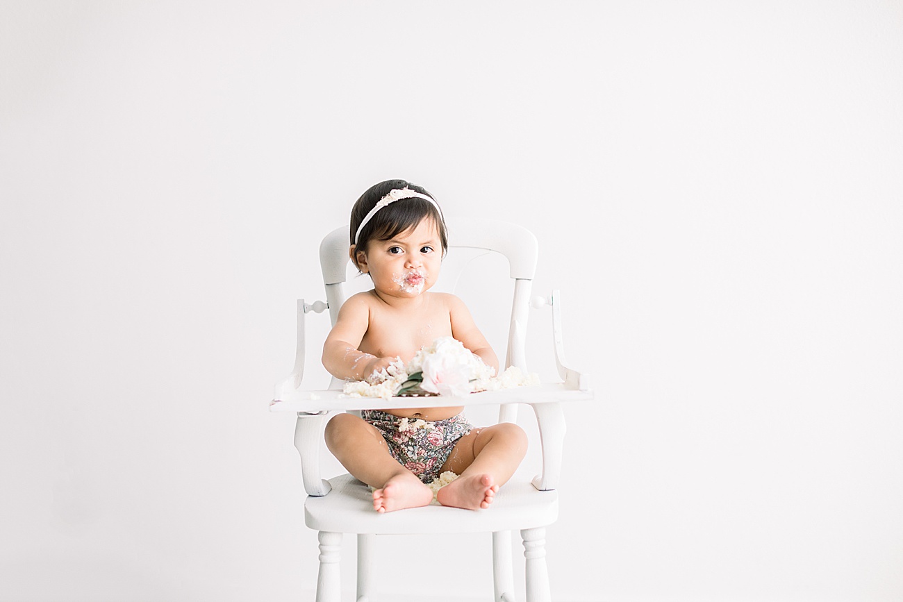 Little girl with the cutest expression during cake smash. Photo by Austin Texas family photographer, Sana Ahmed Photography.