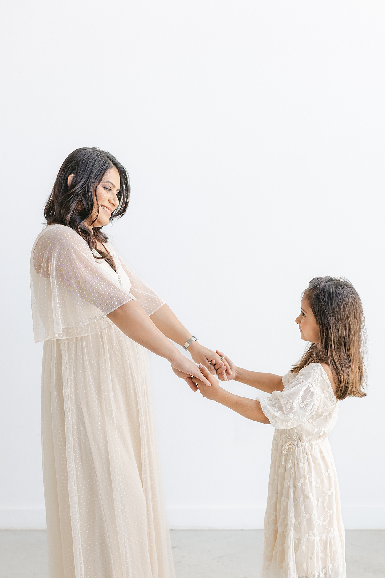 Sweet candid of Mom and daughter dancing in the studio. Photo by Sana Ahmed Photography.