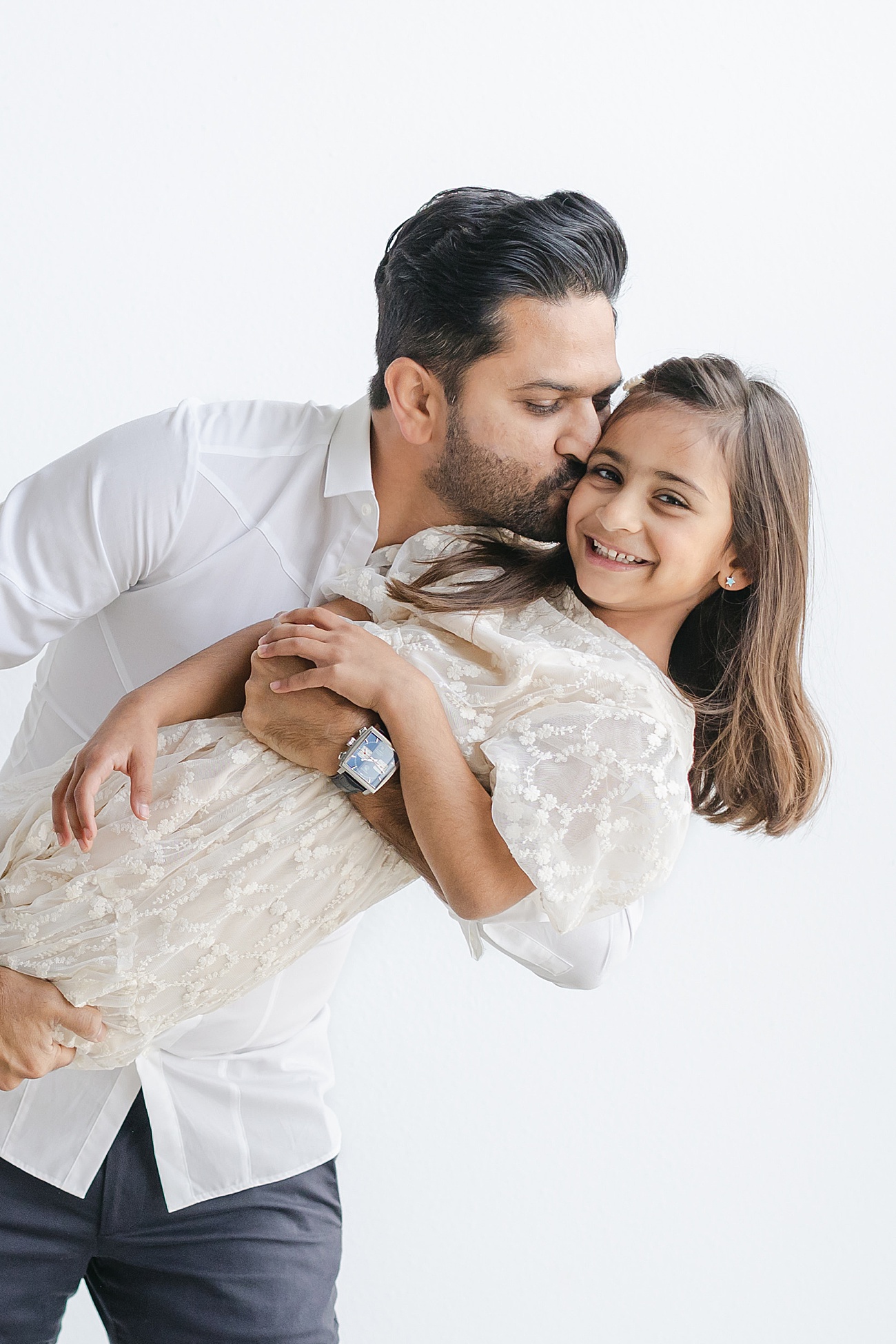 Sweet Daddy and daughter image as Dad kisses her cheek during session with Sana Ahmed Photography.