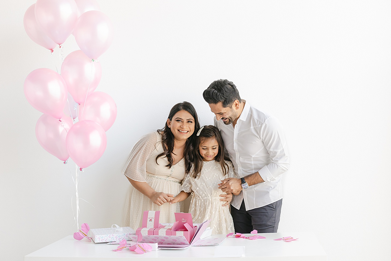 Pink paper butterflies as they come out of the box during a baby gender reveal session in Austin, TX studio. Photo by Sana Ahmed Photography.