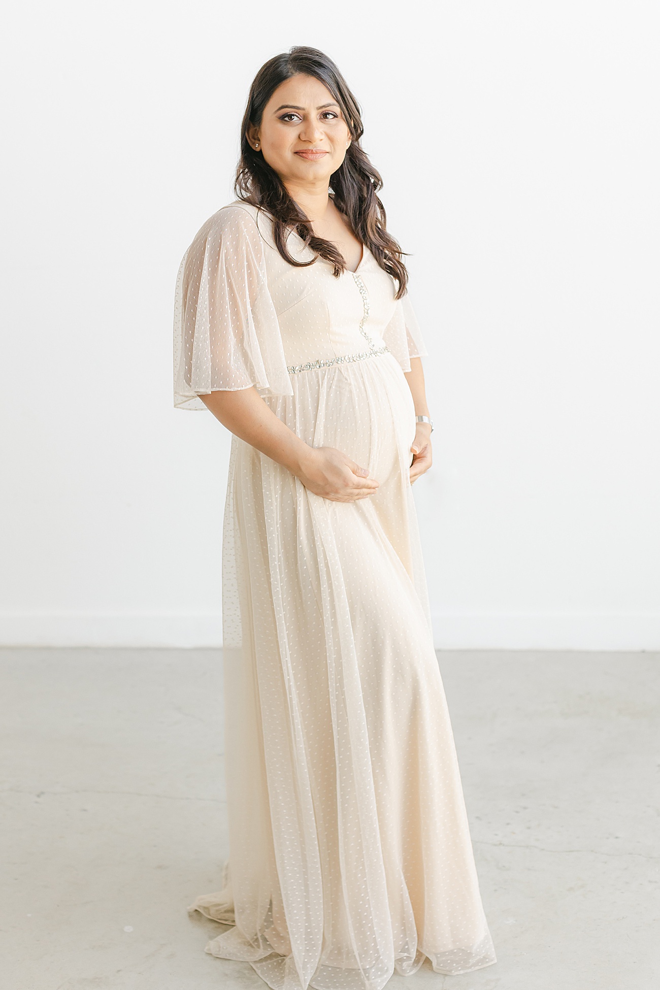 Classic maternity portrait of Mom smiling at camera. Photo by Sana Ahmed Photography.