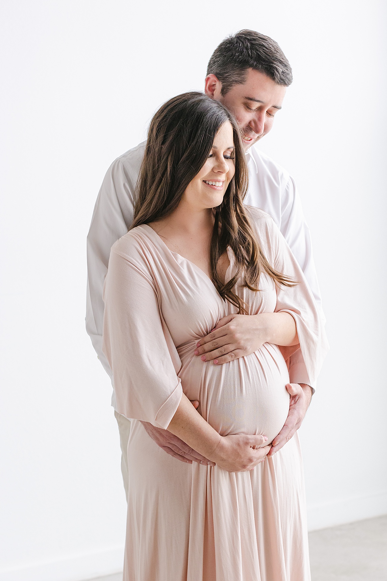 Sweet expecting parents embracing baby bump in photo by Austin maternity photographer, Sana Ahmed Photography.