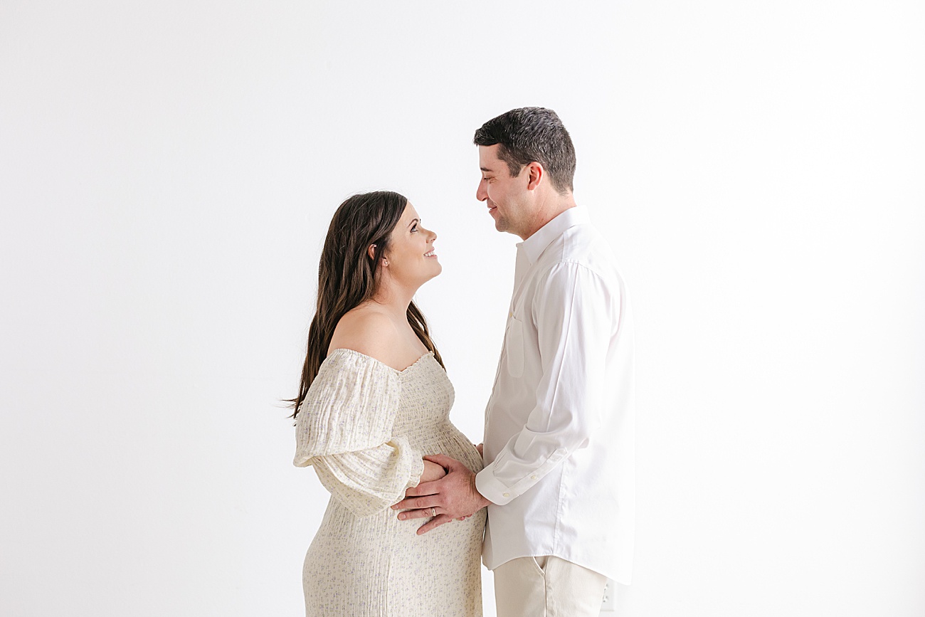 Expecting parents with hands on baby bump. Photo by Sana Ahmed Photography.