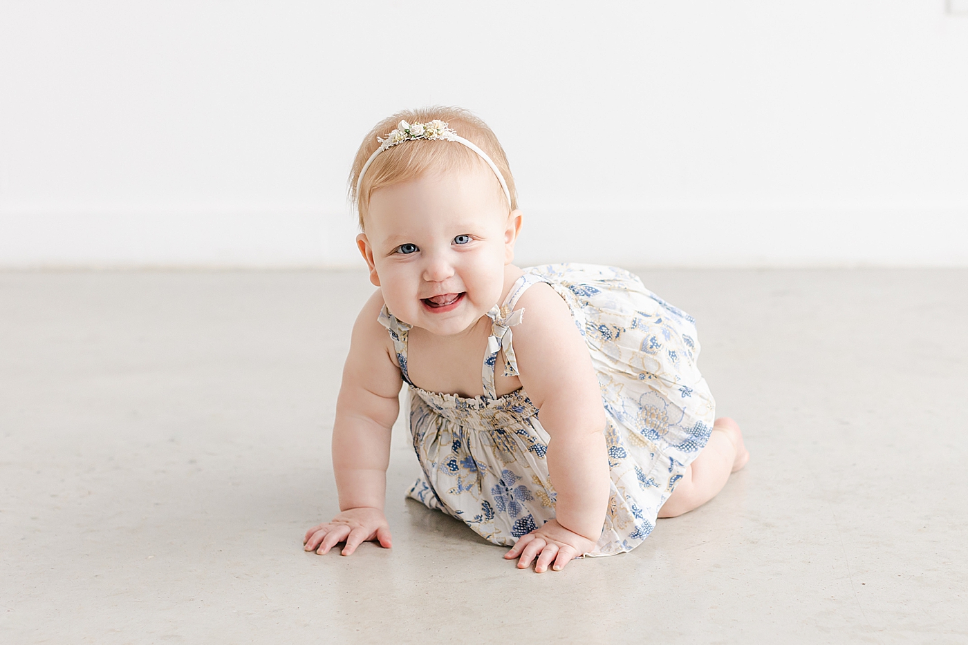 Baby girl in a dress and headband smiling | Sana Ahmed Photography