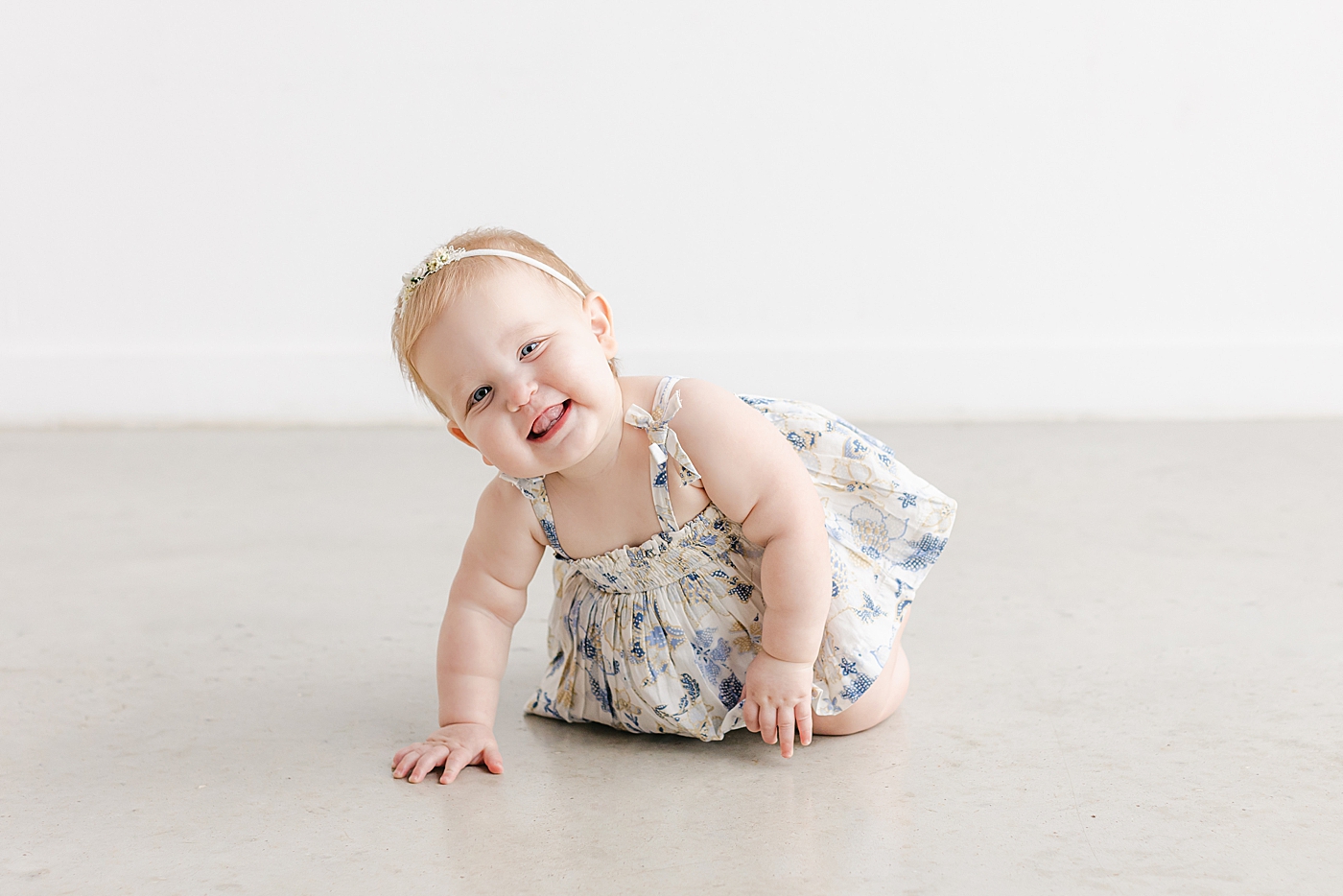 Baby girl in a floral print dress smiling | Photo by Sana Ahmed Photography