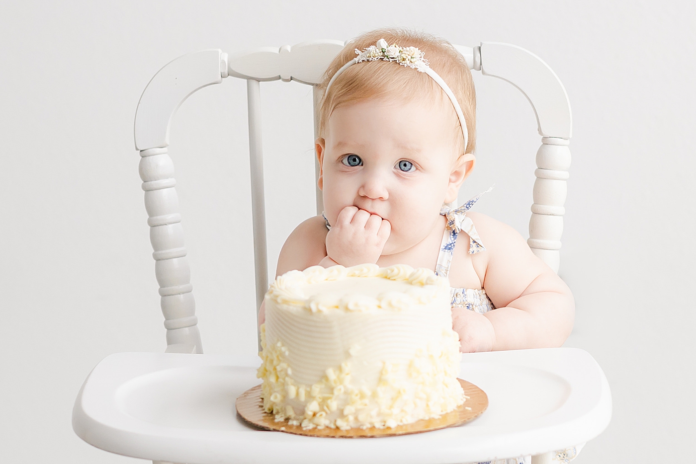 Baby girl with blue eyes eating a smash cake | Sana Ahmed Photography