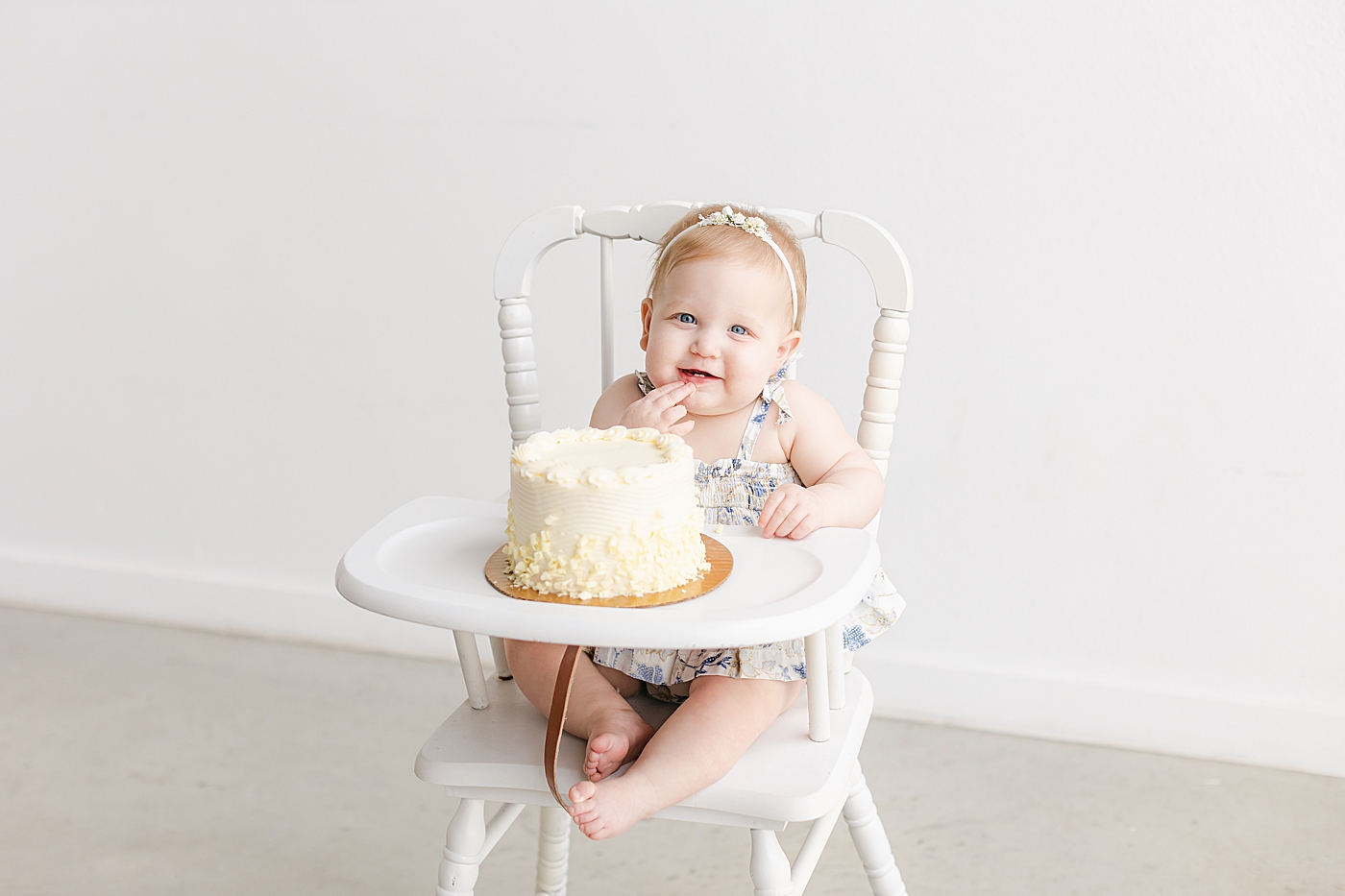 Smiling baby girl in a highchair during her one year milestone session | Sana Ahmed Photography