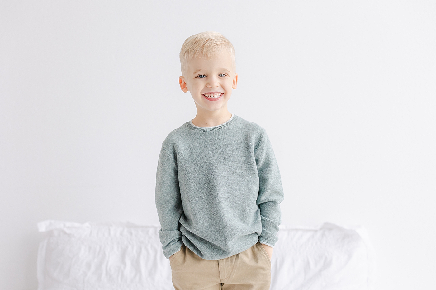 Little boy in a blue sweater with his hands in his pockets | Photo by Sana Ahmed Photography