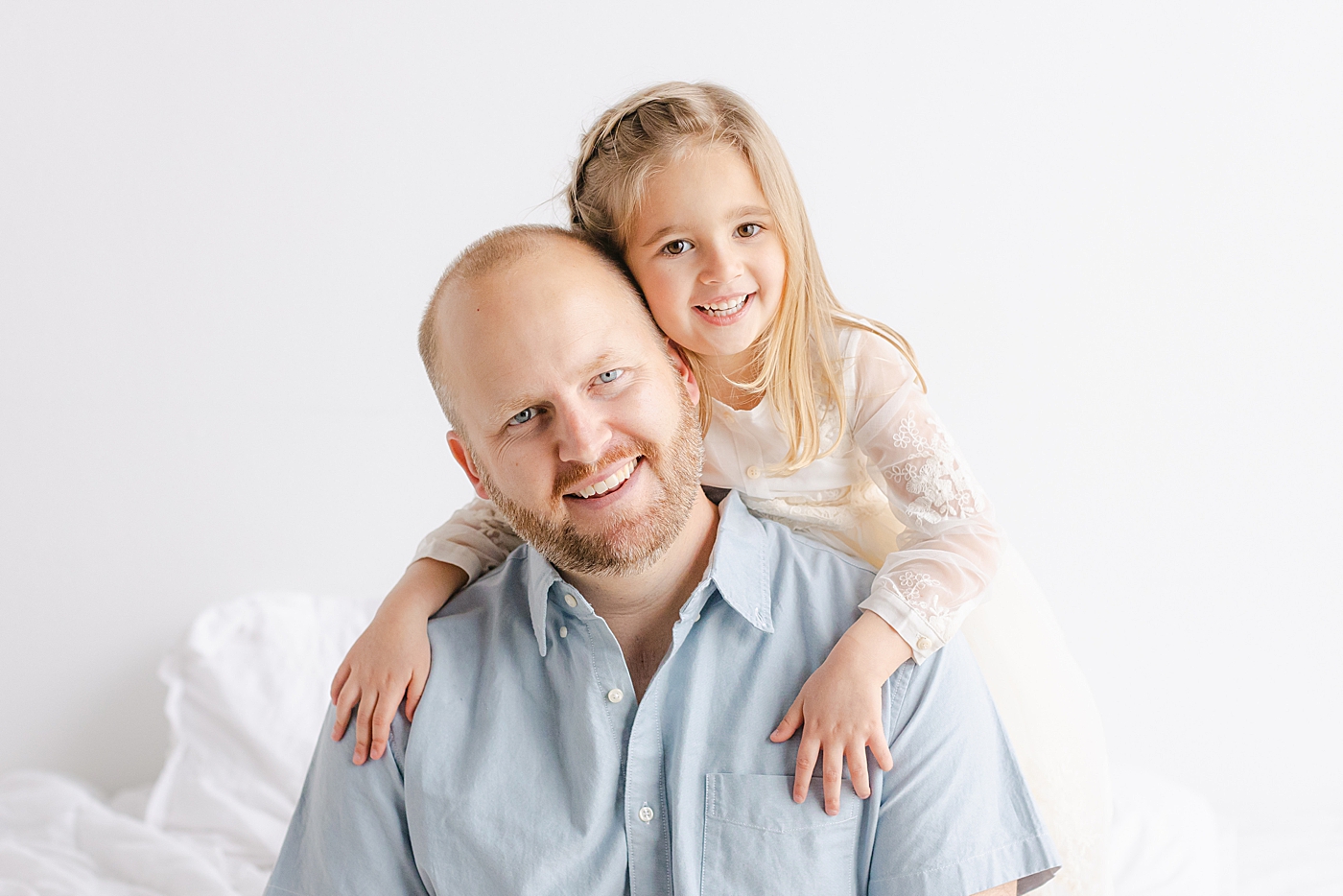 Dad and daughter smiling during their playful family studio session in Austin | Photo by Sana Ahmed Photography
