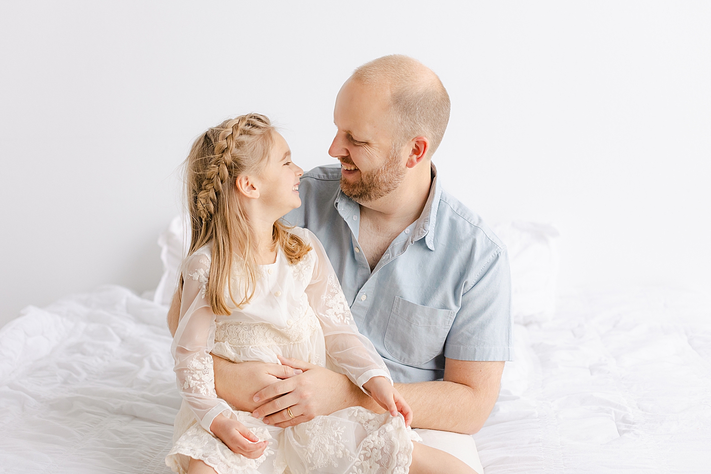 Dad and daughter laughing together during their playful family studio session in Austin | Photo by Sana Ahmed Photography