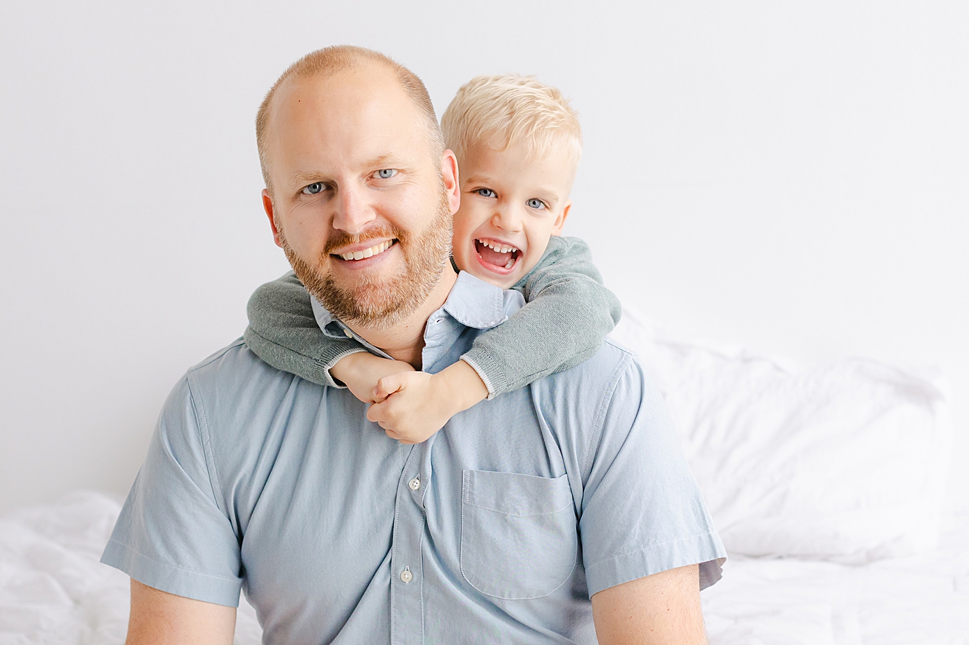 Dad and little boy snuggling during their playful family studio session in Austin | Photo by Sana Ahmed Photography