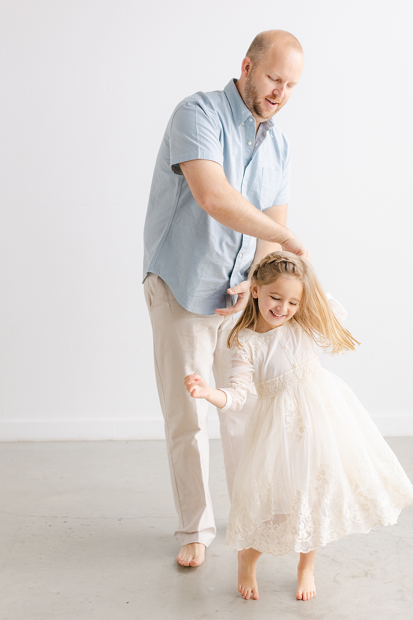 Dad twirling his little girl during their playful family studio session in Austin | Photo by Sana Ahmed Photography