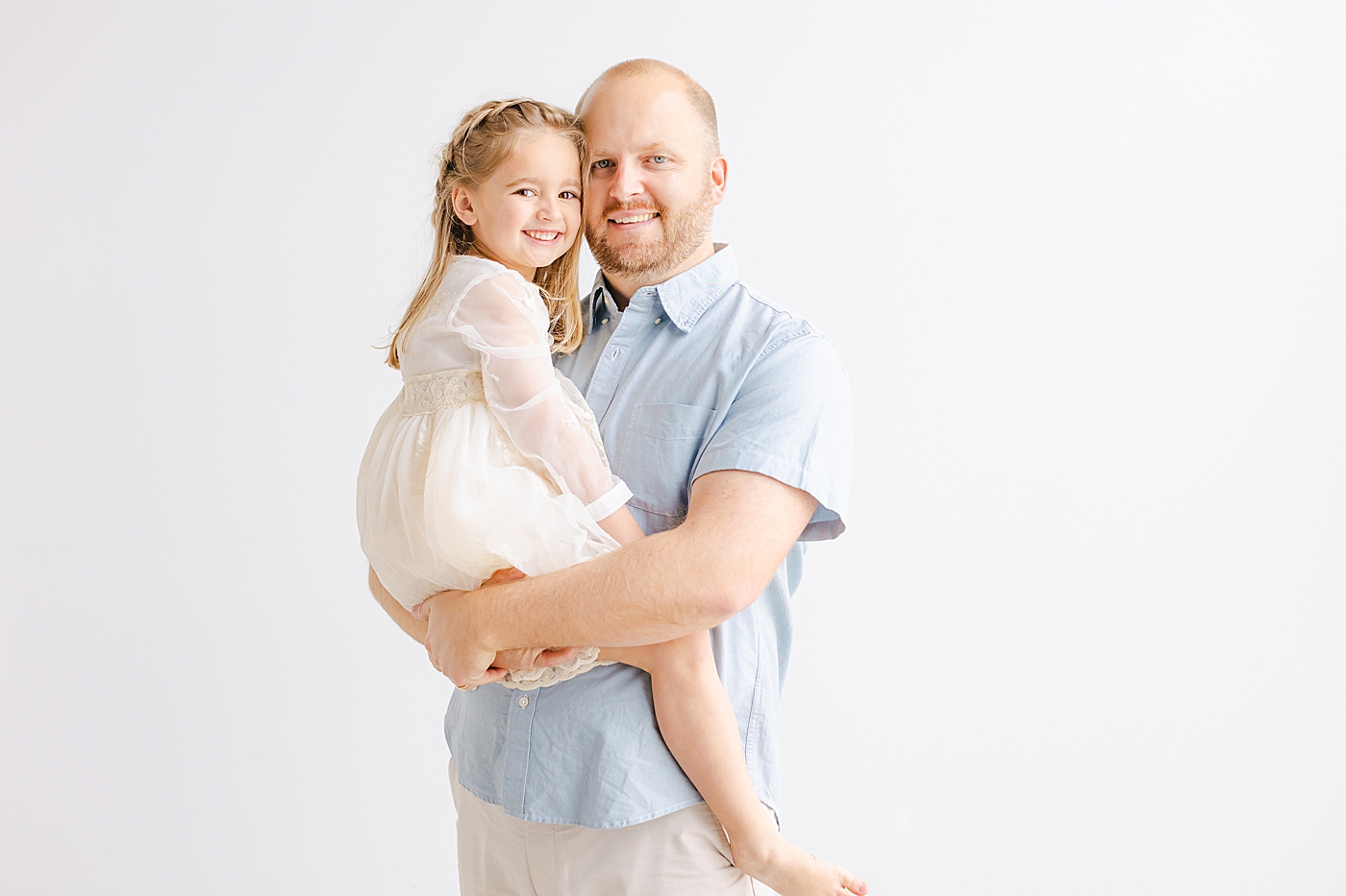 Dad holding his little girl during their playful family studio session in Austin | Photo by Sana Ahmed Photography
