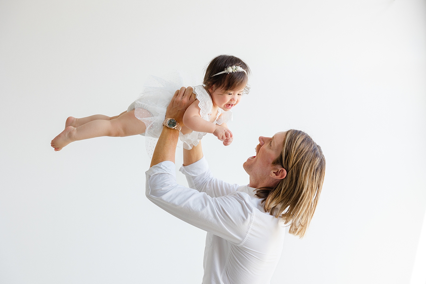 Dad playing with his baby girl during her one year studio milestone session| Image by Sana Ahmed Photography