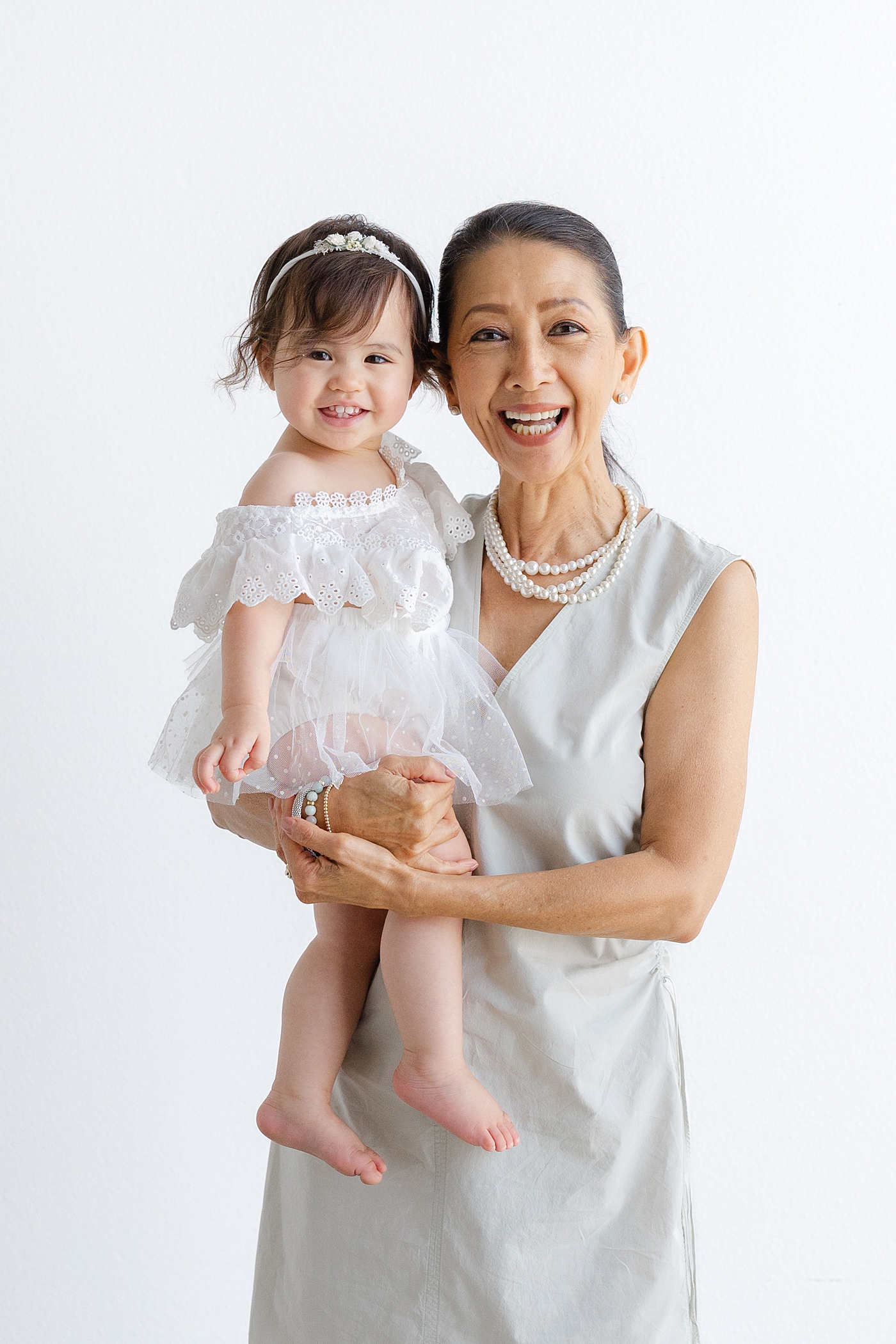 Baby girl with her grandma smiling during her one year studio milestone session| Image by Sana Ahmed Photography