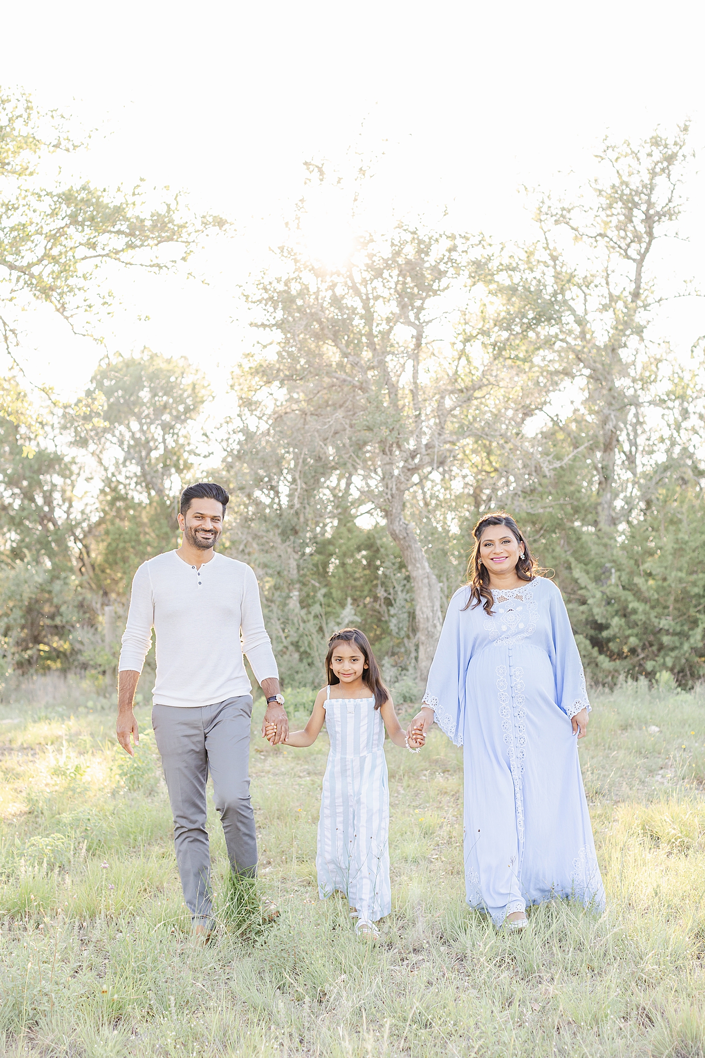 Family of three walking together during their Outdoor Maternity Session in Austin | Photo by Sana Ahmed Photography