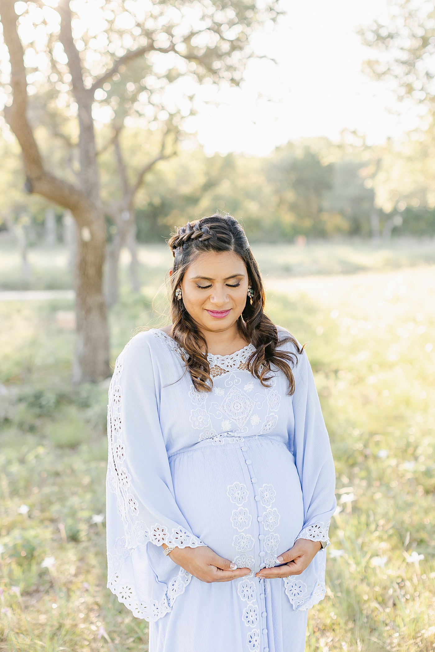 Mom holding her belly during their Outdoor Maternity Session in Austin | Photo by Sana Ahmed Photography