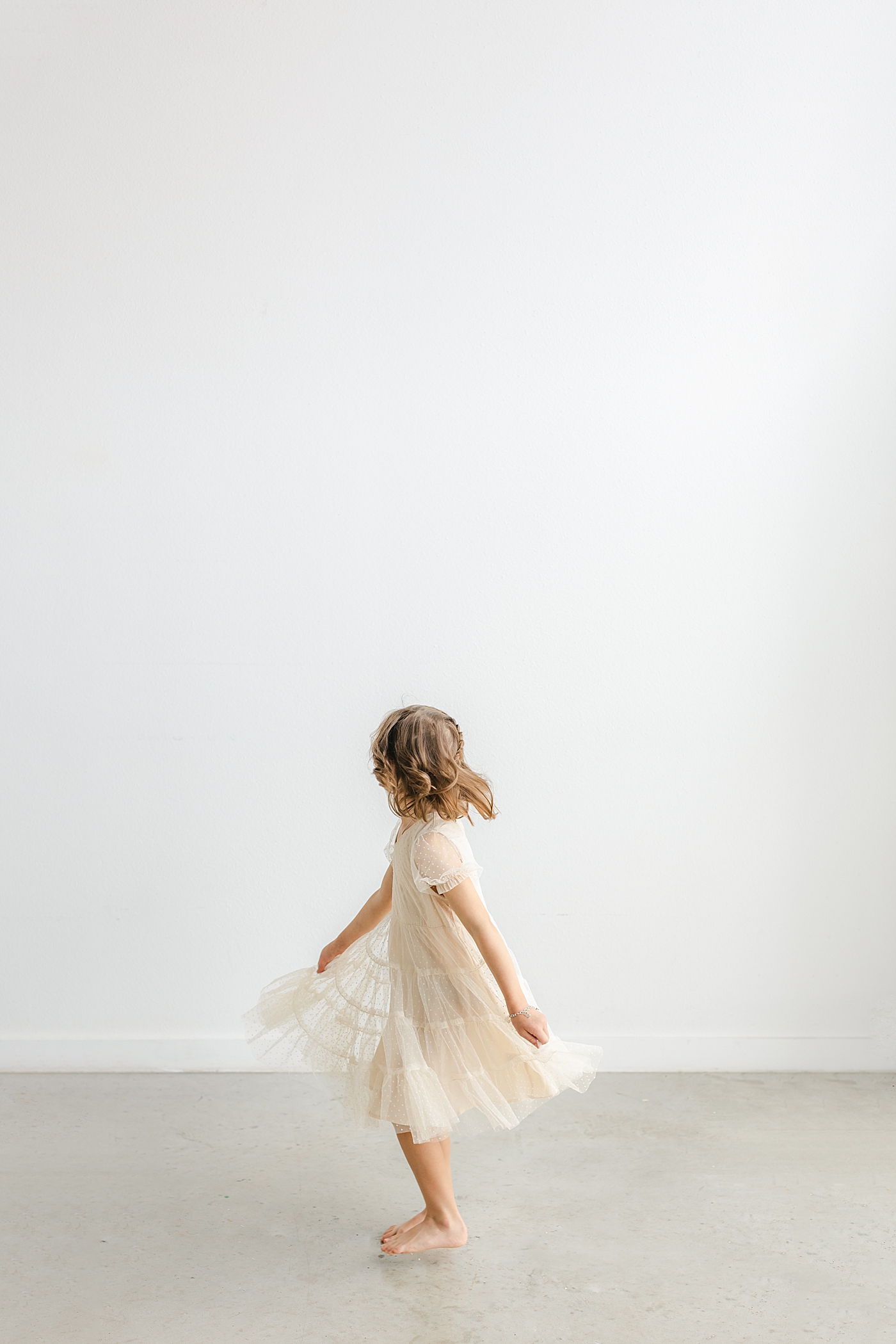 Little girl twirling during Studio Family Session in Austin | Photo by Sana Ahmed Photography