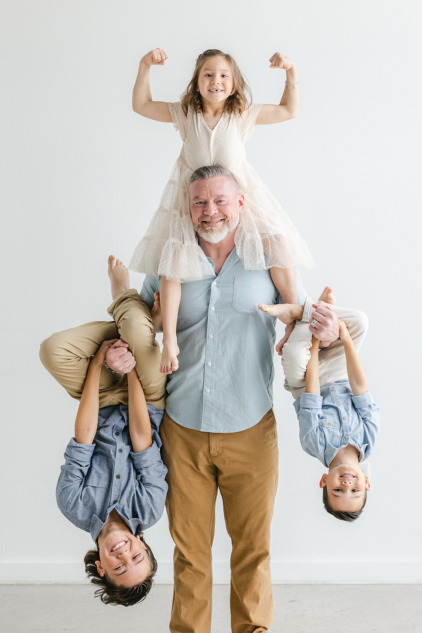 Dad holding all three of his kids during their Studio Family Session in Austin | Photo by Sana Ahmed Photography