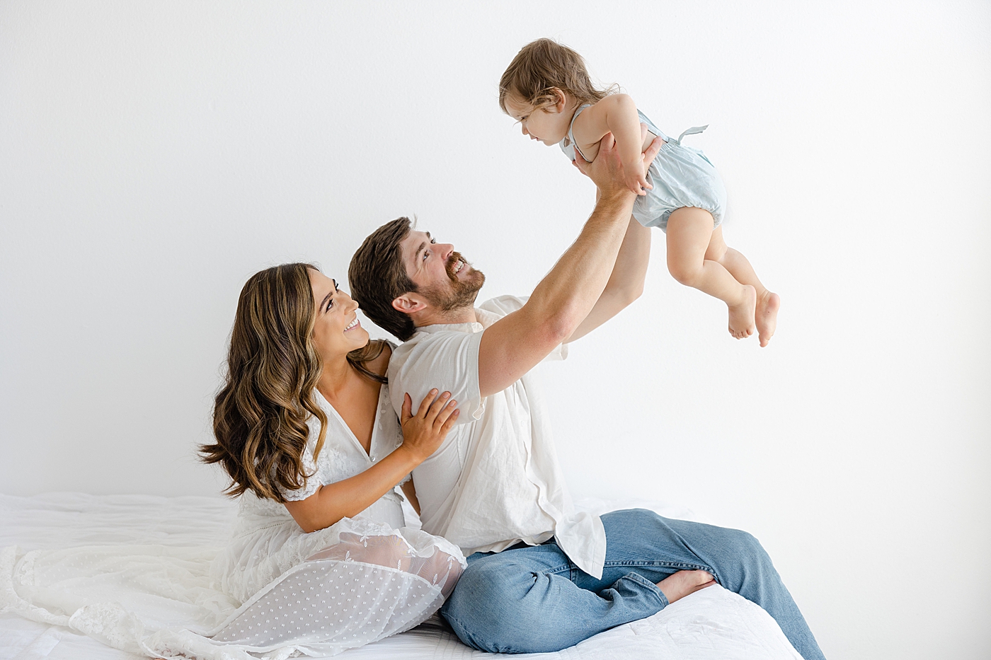 Mom and dad playing airplane with their baby girl during their Studio Family Session | Photo by Sana Ahmed Photography