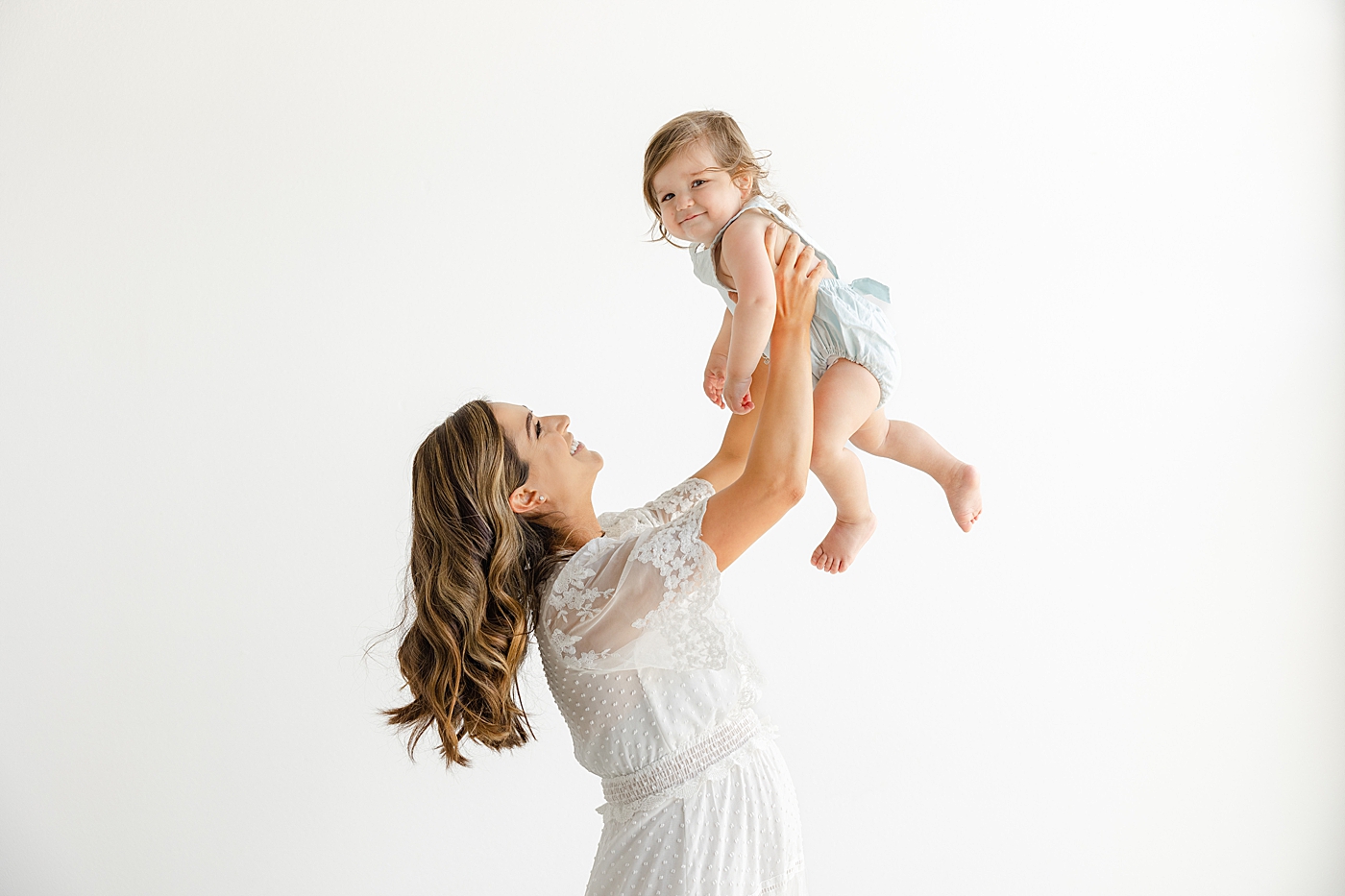Mom playing airplane with her baby girl during their Studio Family Session | Photo by Sana Ahmed Photography