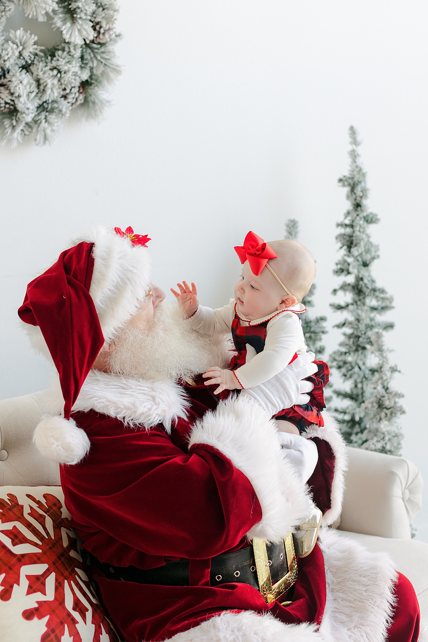 Baby girl reaching for Santas beard during Santa Sessions in Austin | Images by Sana Ahmed Photography