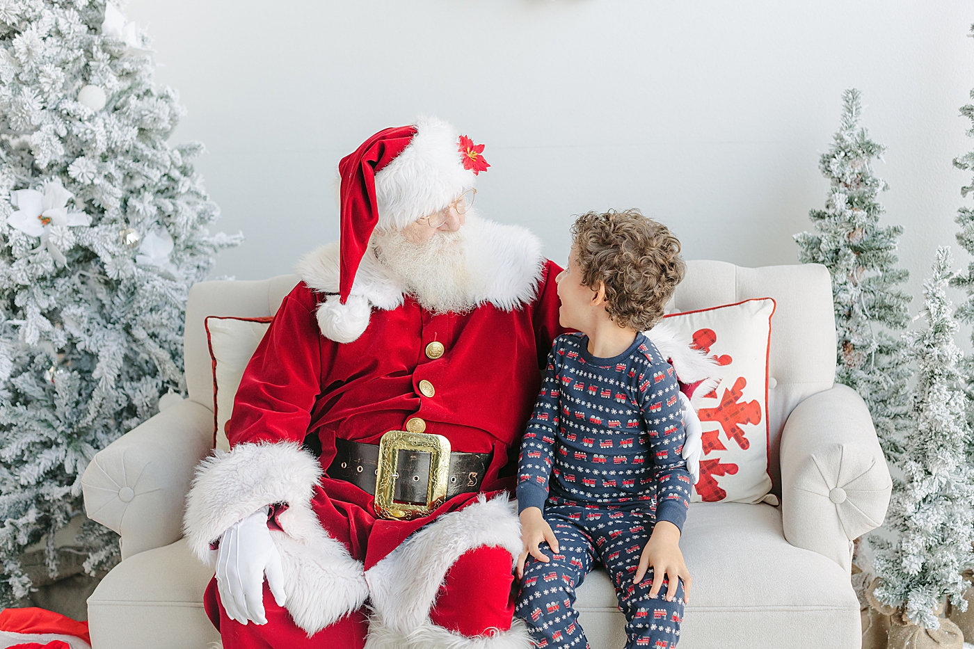 Little boy in pajamas sitting with Santa during Santa Sessions in Austin | Images by Sana Ahmed Photography