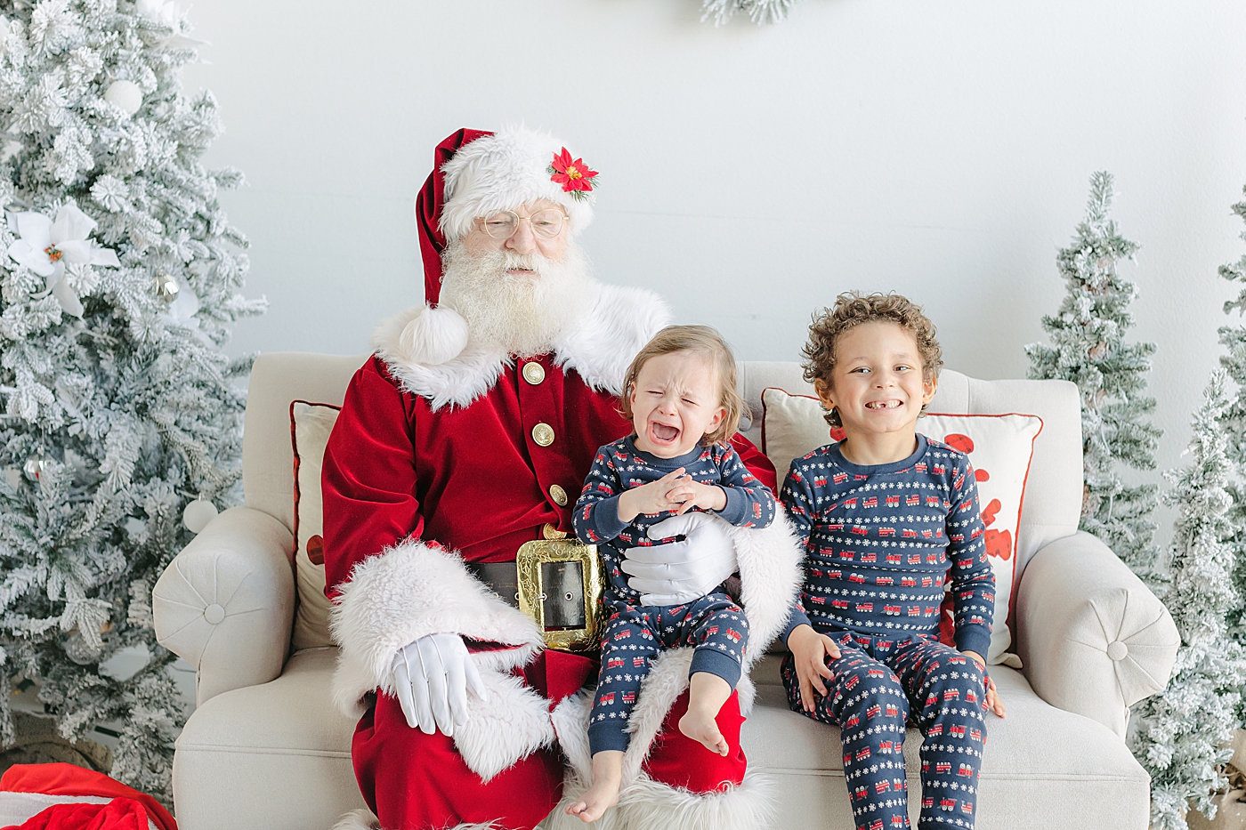 Siblings in Christmas pajamas sitting with Santa | Images by Sana Ahmed Photography