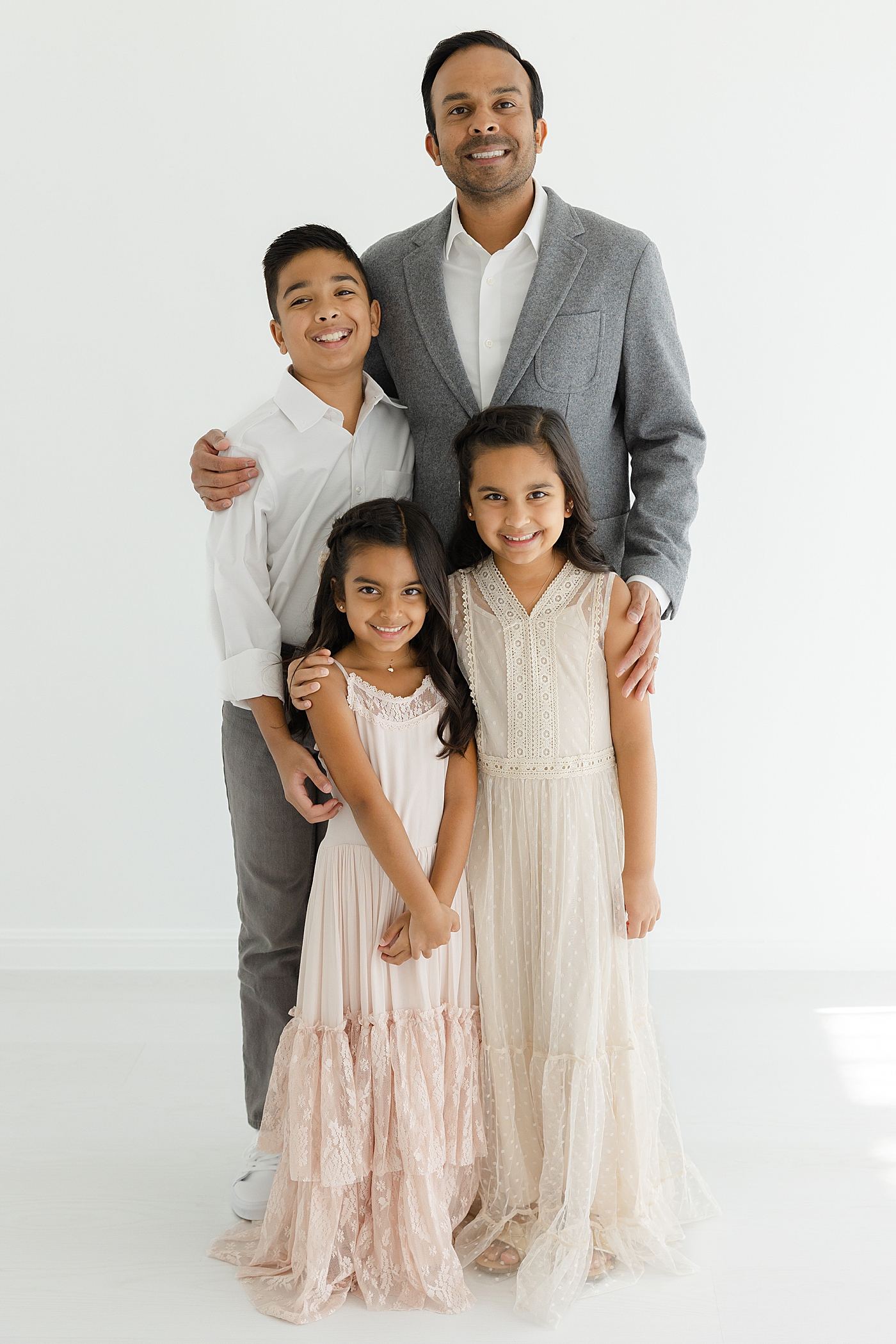 Dad posing with his three children in the studio | Image by Sana Ahmed Photography