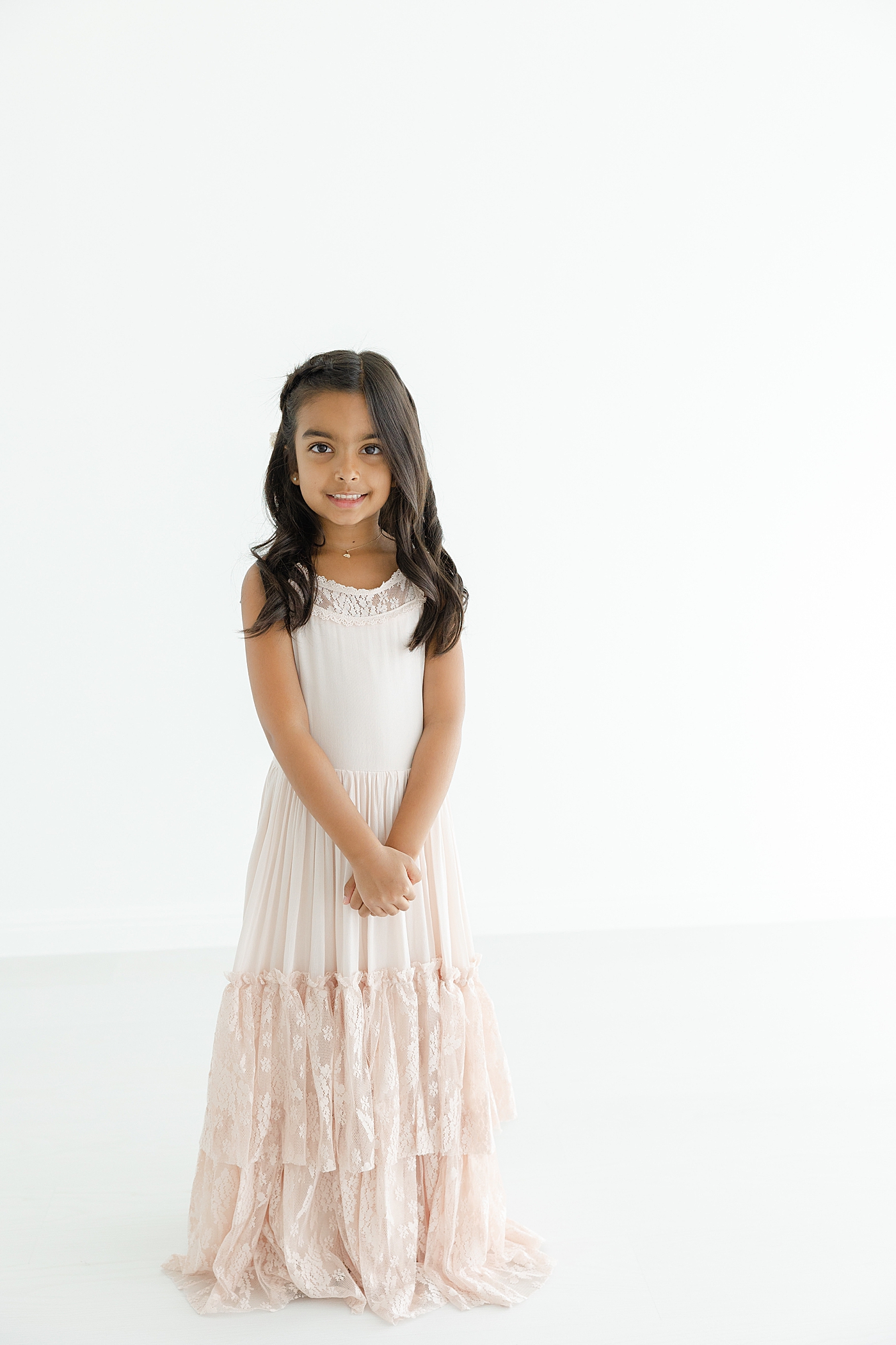 Little girl with dark hair in a long pink light gray dress | Image by Sana Ahmed Photography