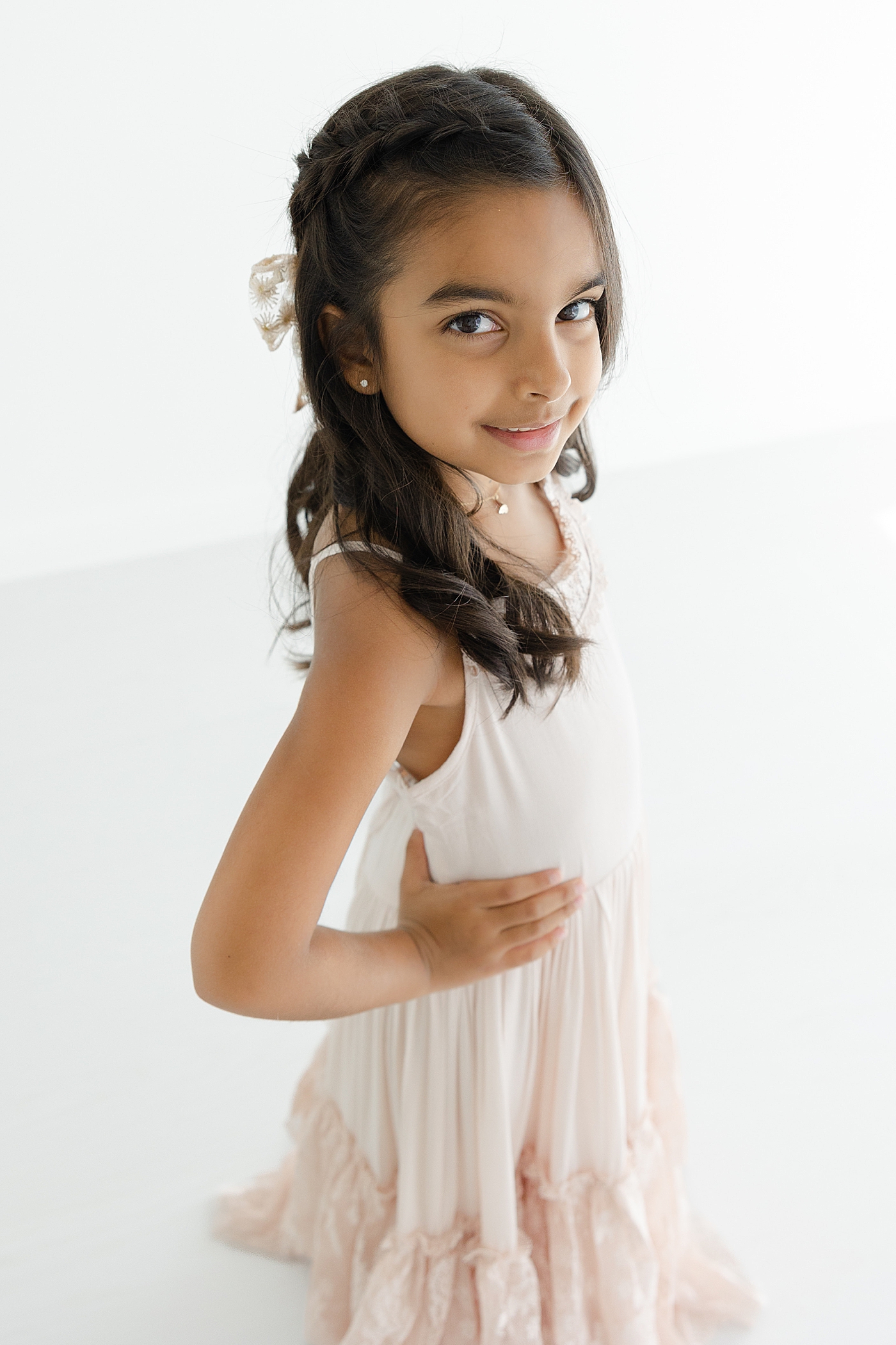 Little girl with brown hair in a pink maxi dress | Image by Sana Ahmed Photography