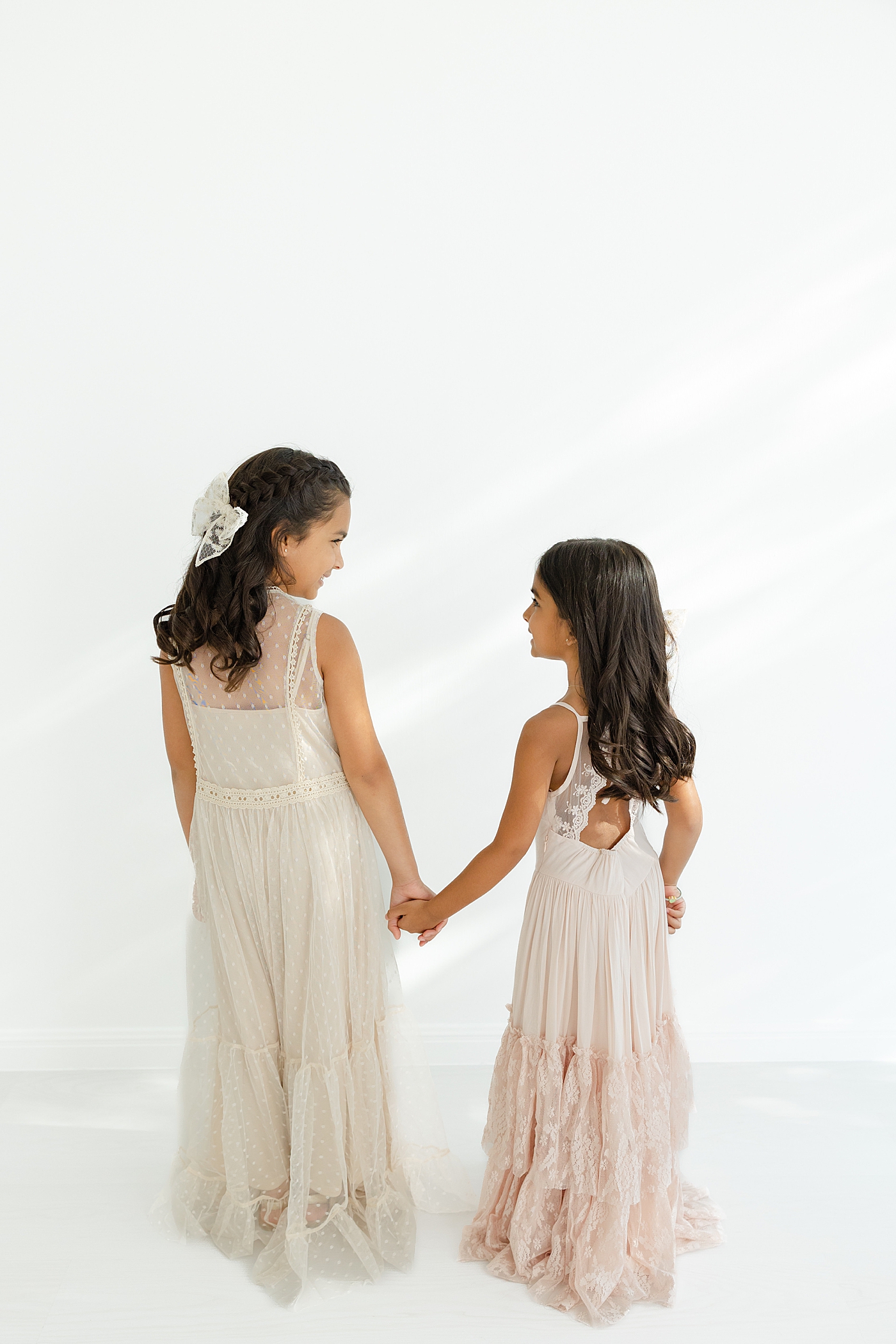 Two sisters in long maxi dresses holding hands | Image by Sana Ahmed Photography