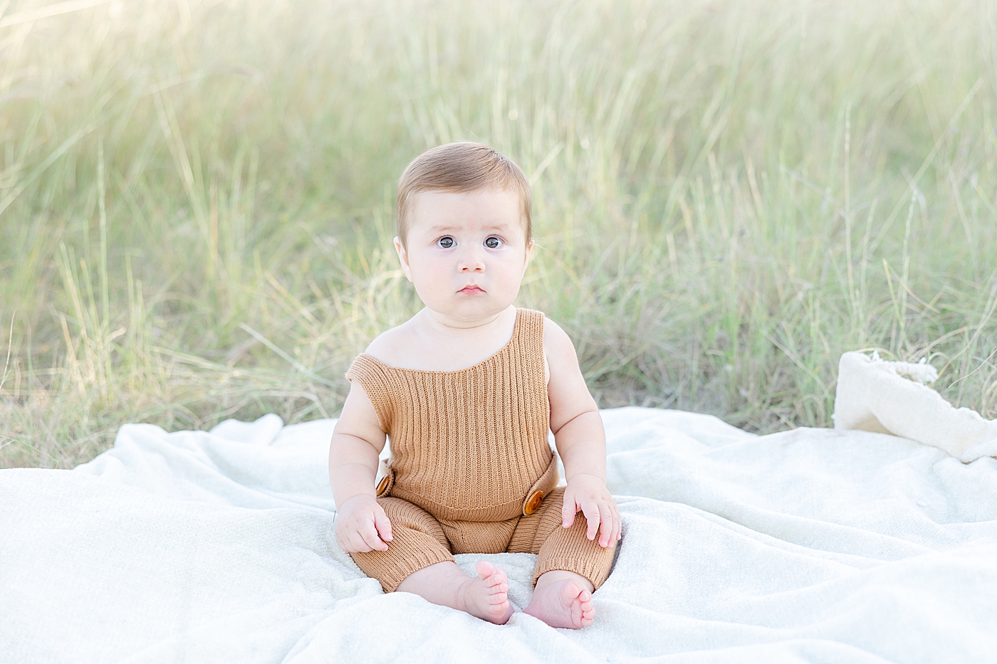 Baby boy in brown jumpsuit during Six Month Milestone Session | Image by Sana Ahmed Photography