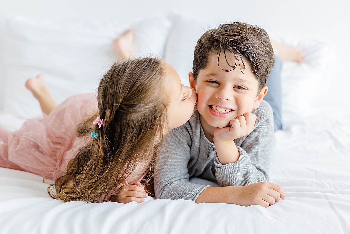 Brother and sister interacting sitting on a bed | Studio Family Sessions Austin with Sana Ahmed Photography
