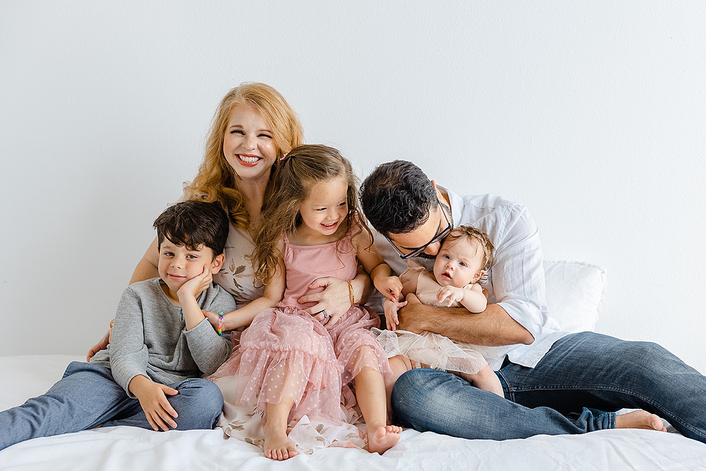 Family interacting sitting on a bed | Studio Family Sessions Austin with Sana Ahmed Photography