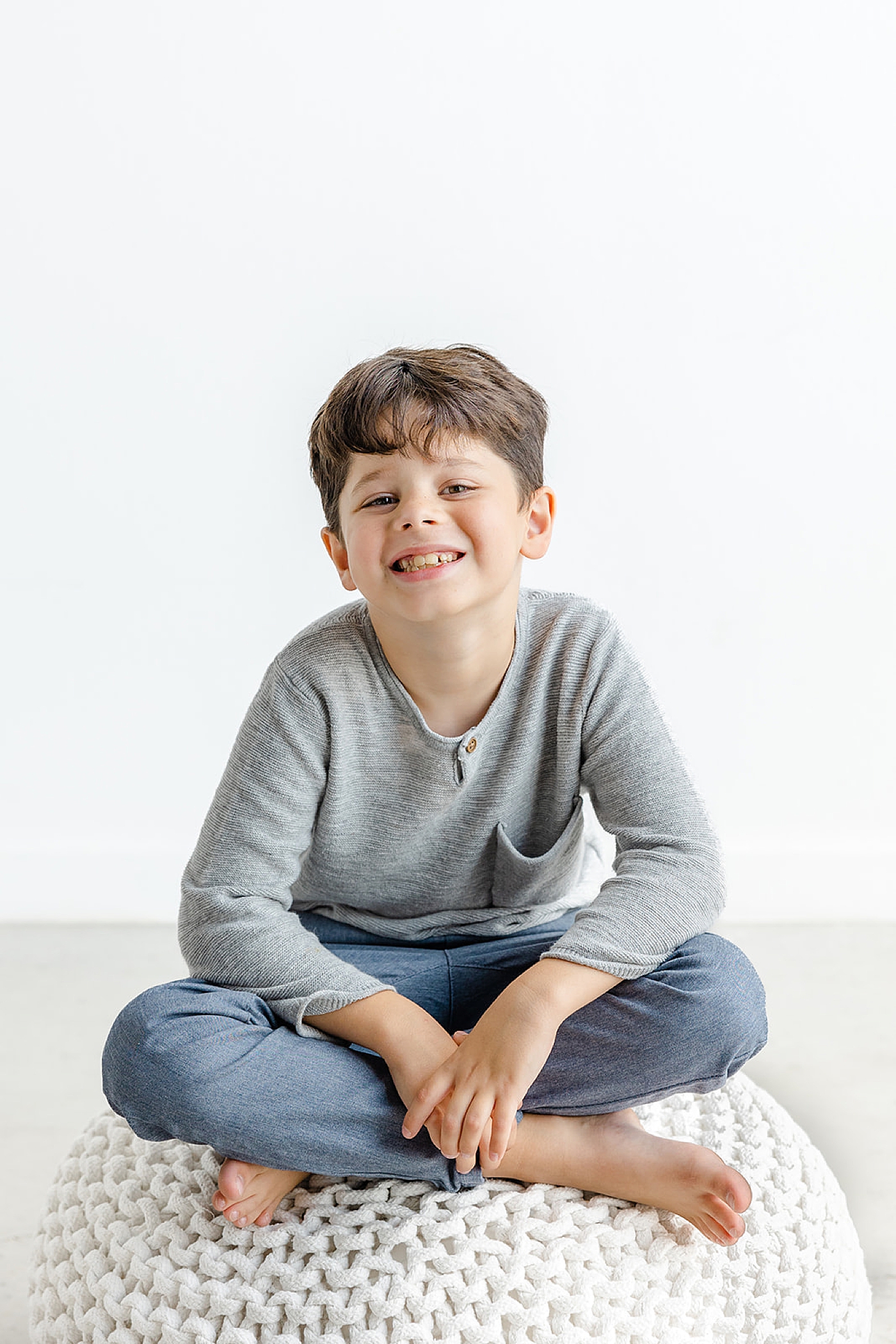 Little boy in gray sitting on an pouf | Studio Family Sessions Austin with Sana Ahmed Photography