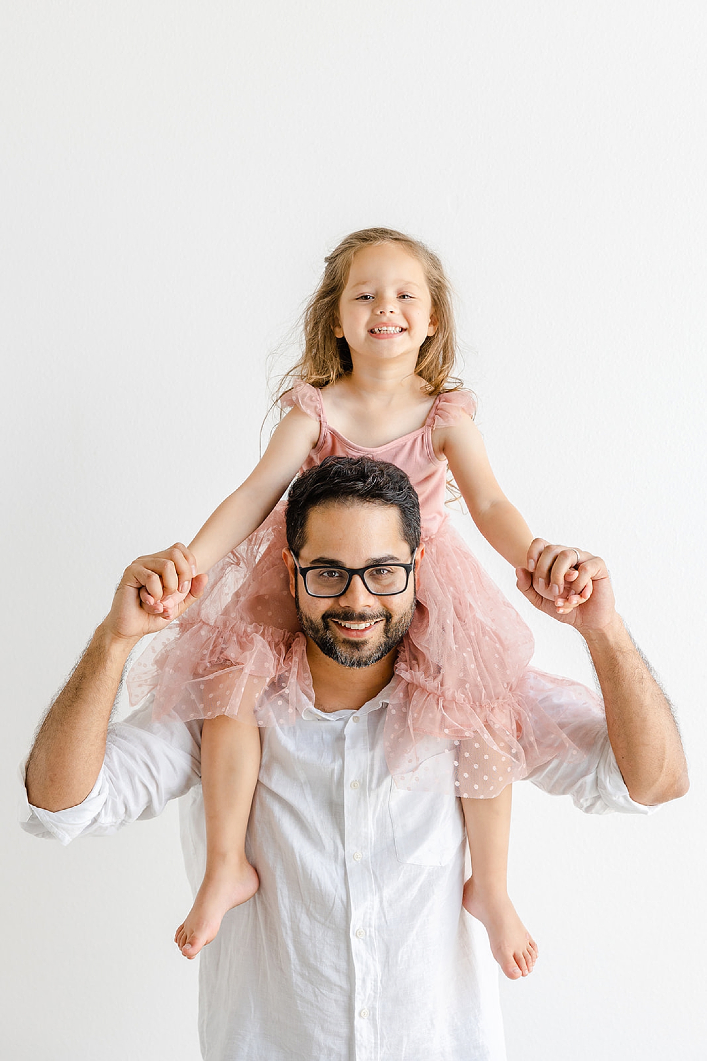 Dad with his daughter in pink on his shoulders | Image by Sana Ahmed Photography
