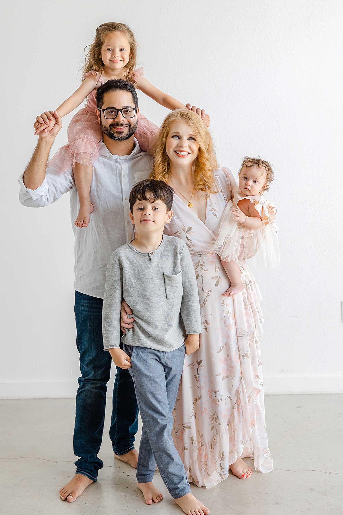 Mom and dad with their three little ones in pink and blue | Studio Family Sessions Austin with Sana Ahmed Photography