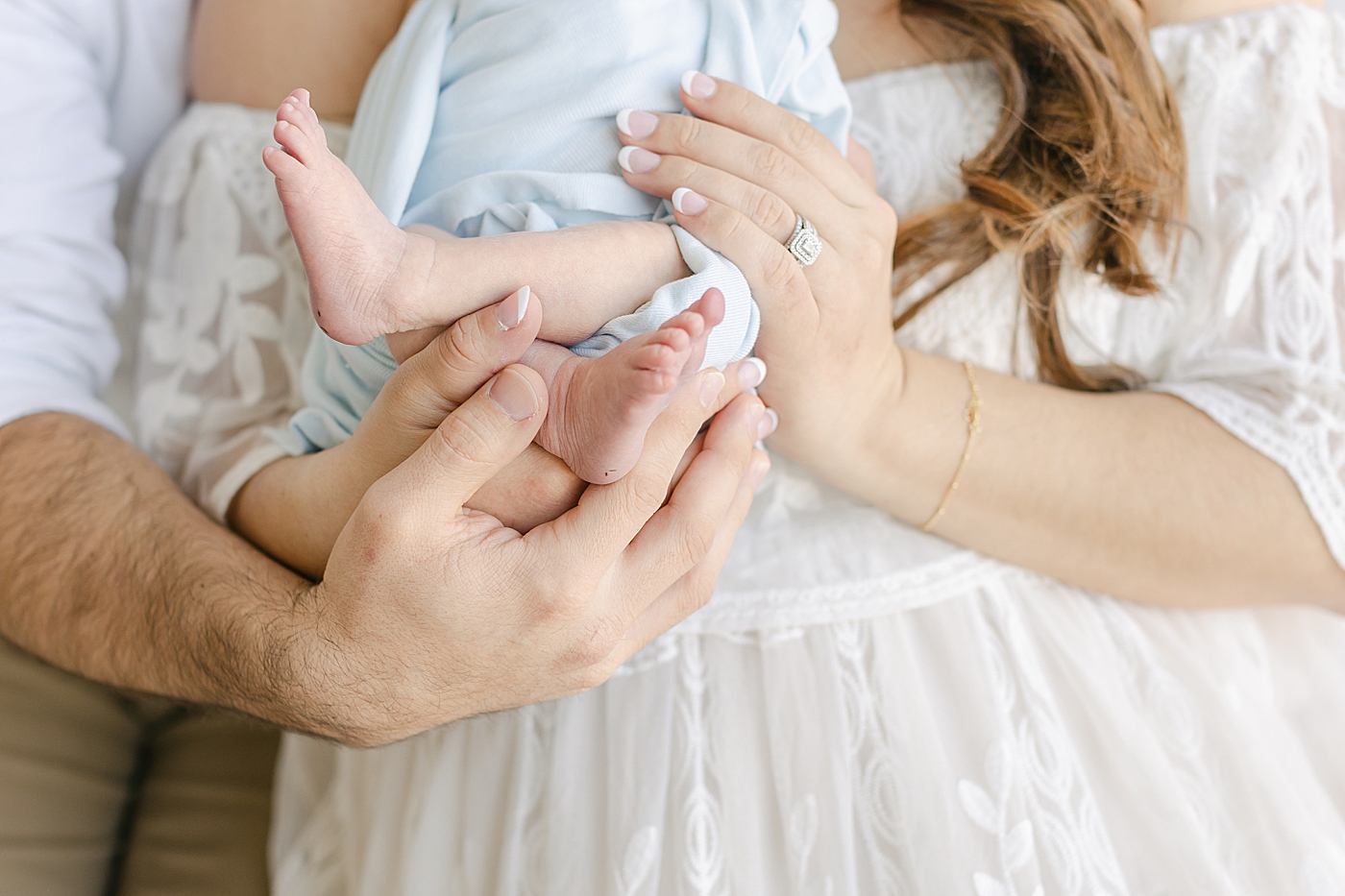 Detail of mom and dad's hands holding their newborn baby | Image by Sana Ahmed Photography 