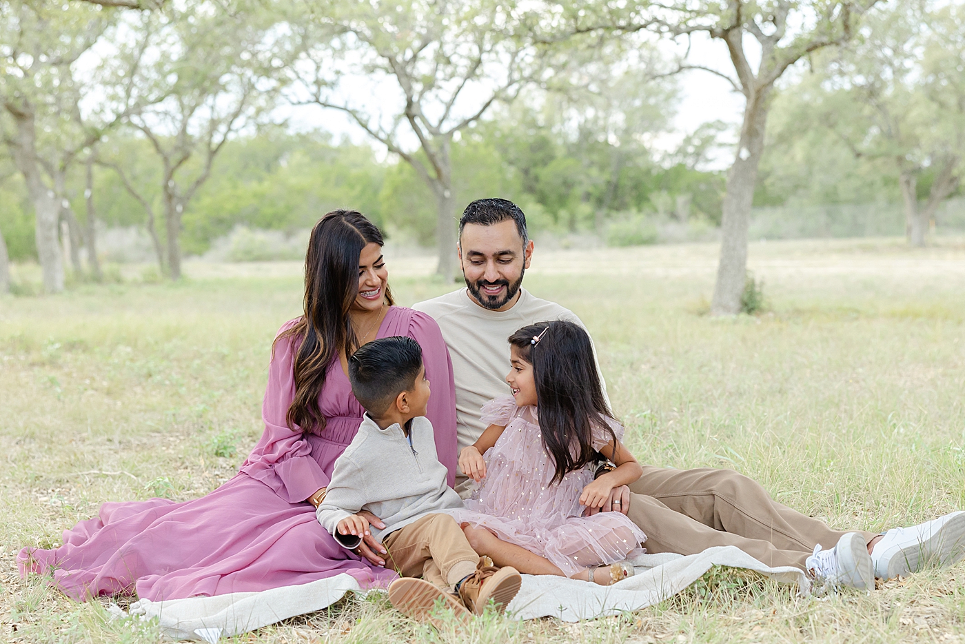 Family of four sitting on a blanket during their Field Family Session | Image by Sana Ahmed Photography