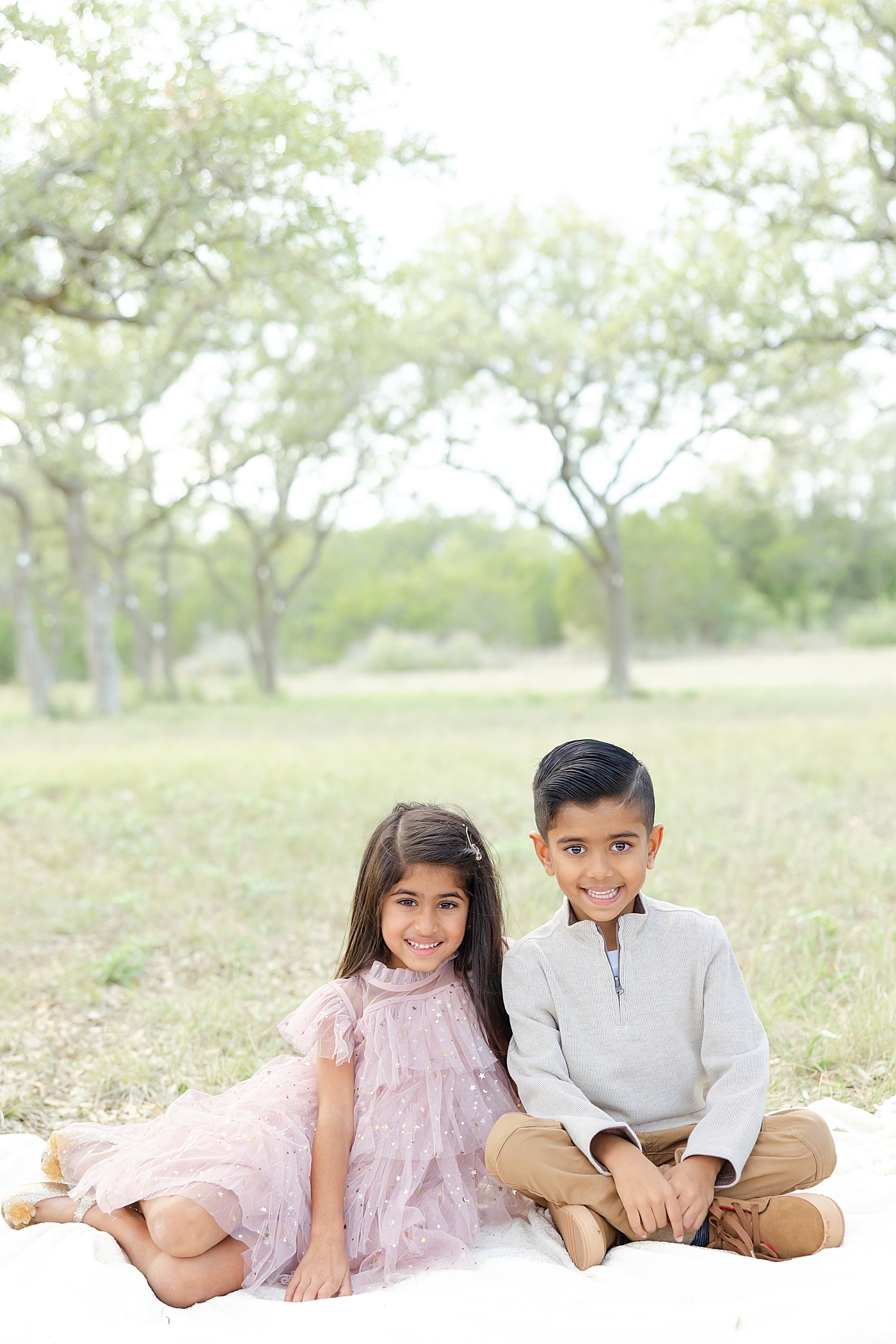 Siblings sitting on a blanket during their Field Family Session | Image by Sana Ahmed Photography