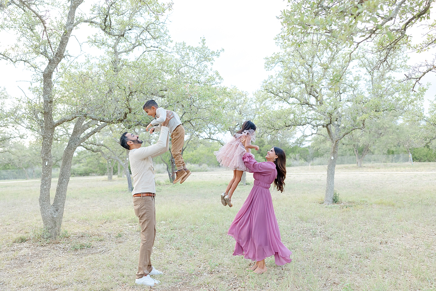Mom and dad playing with their two kids during their Field Family Session | Image by Sana Ahmed Photography
