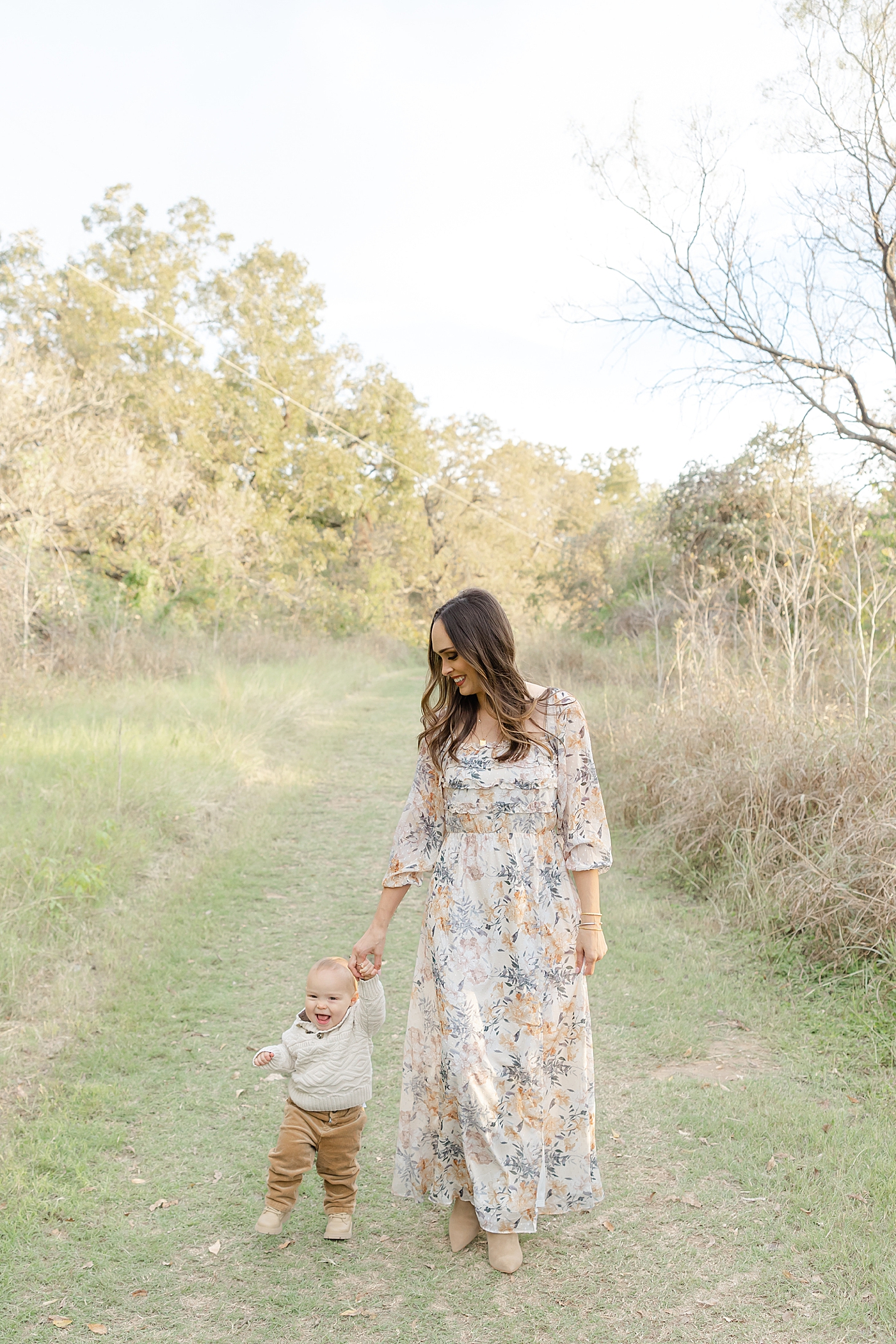 Mom walking with her baby boy in the park during their Spring Family Sessions in Austin | Image by Sana Ahmed Photography