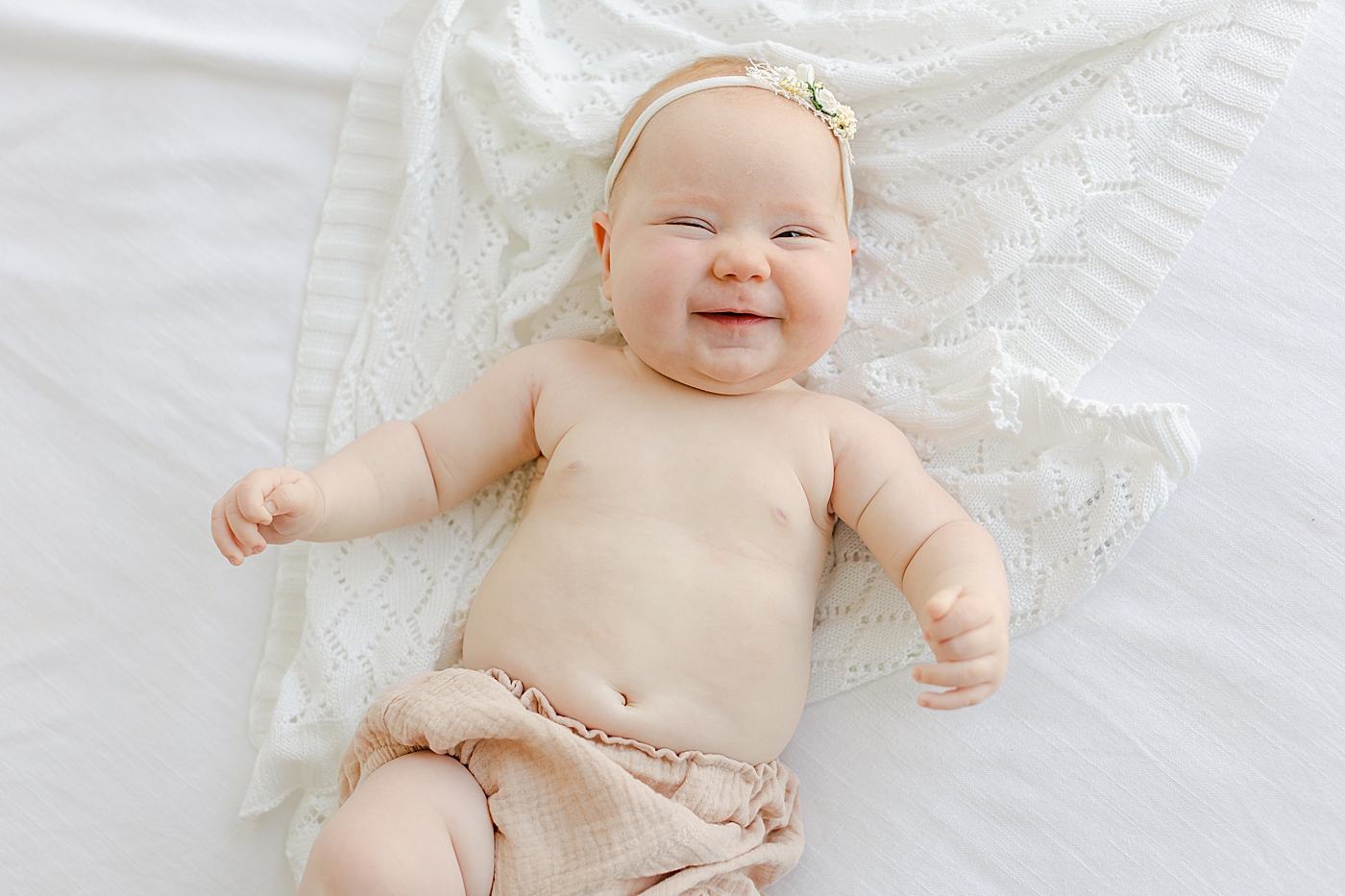 Smiling baby girl in pink bloomers | Image by Sana Ahmed Photography