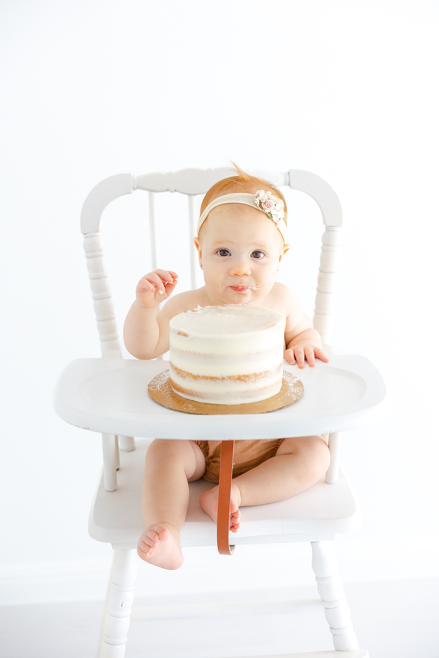Baby girl eating her smash cake during her One Year Milestone Collection | Image by Sana Ahmed Photography