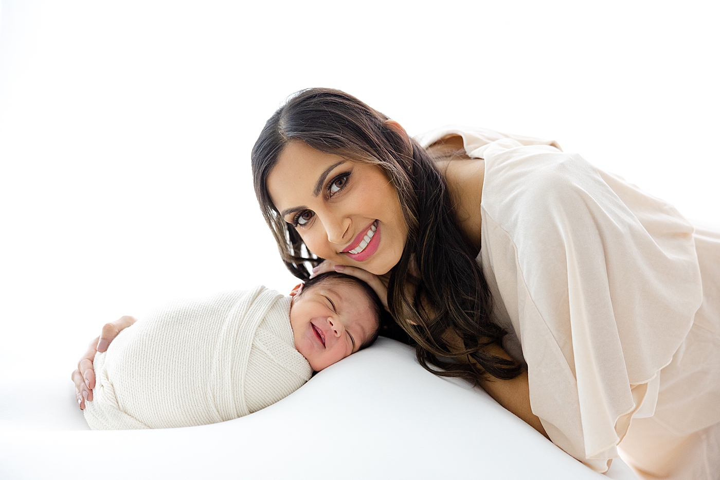 Mom snuggling with her newborn during their Studio Newborn Session in Austin | Image by Sana Ahmed Photography 