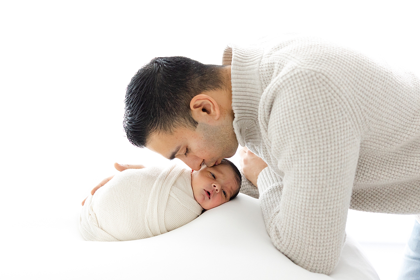 Dad kissing his newborn baby | Image by Sana Ahmed Photography 