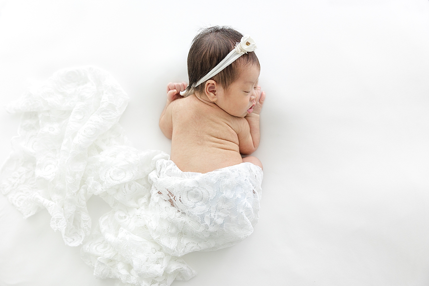 Sleeping newborn wrapped in a piece of lace | Image by Sana Ahmed